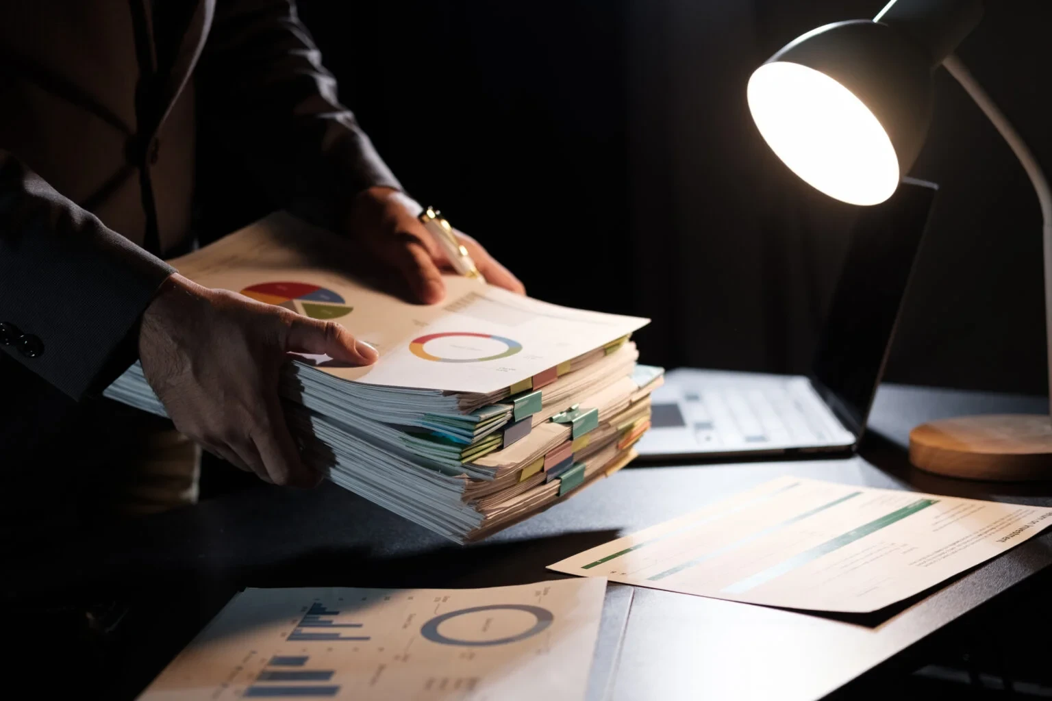 Person organizing financial documents at night